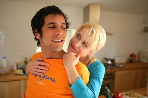 Couple stood hugging in the kitchen — Stock Photo, Image