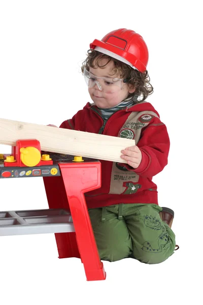Bambino che gioca con un banco da lavoro giocattolo — Foto Stock