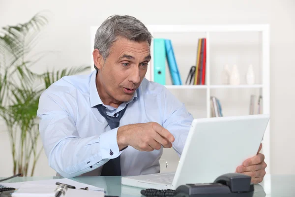 Affärsman skratta framför en laptop — Stockfoto