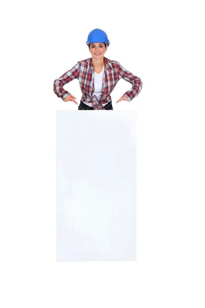 Female mason pointing at white poster — Stock Photo, Image