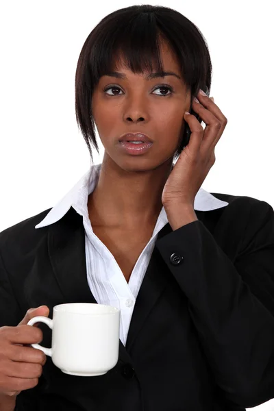 En affärskvinna över telefon dricka en kopp kaffe. — Stockfoto