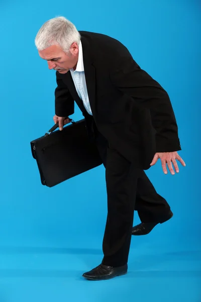 A mature businessman off balance. — Stock Photo, Image