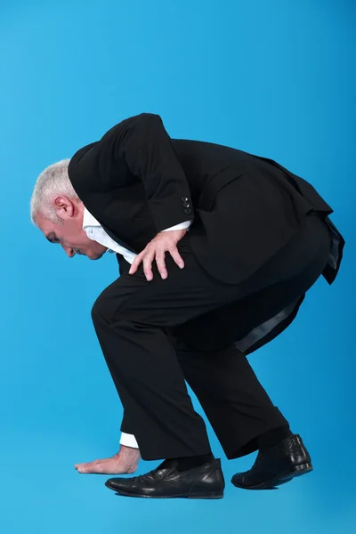 Empresário tocando o chão — Fotografia de Stock
