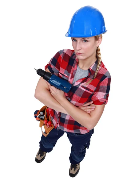 Агрессивная женщина-строитель держит дрель — стоковое фото