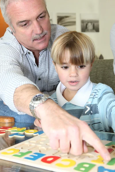 Дедушка учит своего внука читать — стоковое фото