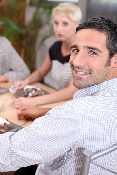 Uśmiechnięty mężczyzna siedzący przy stole — Zdjęcie stockowe