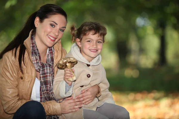 Mother and daughter gathering mushroom — Stock Photo, Image