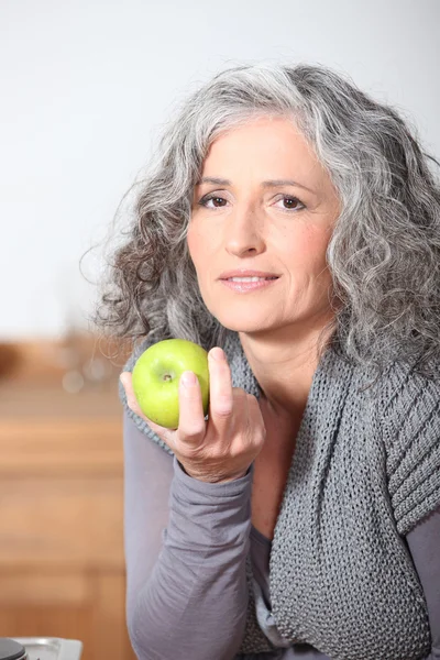 Belle femme mature mangeant de la pomme verte — Photo