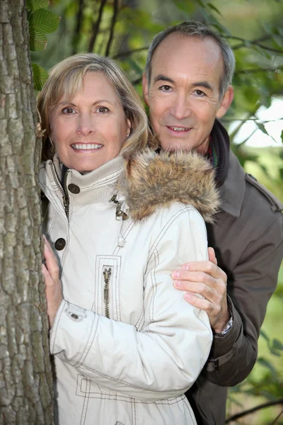 Mature couple out for an autumnal stroll in the woods — Stock Photo, Image