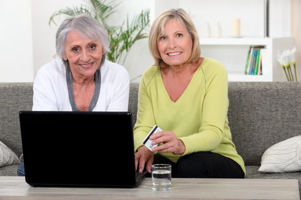 Las mujeres mayores utilizando una tarjeta de crédito en línea — Foto de Stock