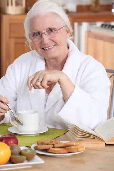 Velha senhora tomando café da manhã — Fotografia de Stock