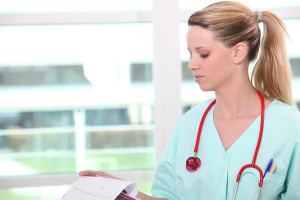 Eine Krankenschwester liest eine Zeitung — Stockfoto
