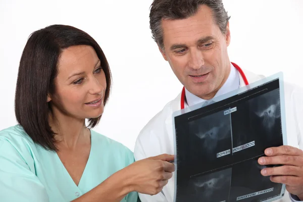 Медсестра и рентгенолог смотрят рентген — стоковое фото