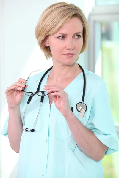 Медсестра держит очки — стоковое фото