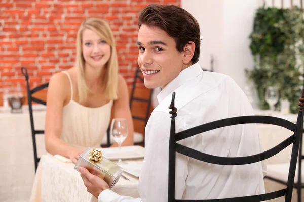 Couple in restaurant with present Royalty Free Stock Images