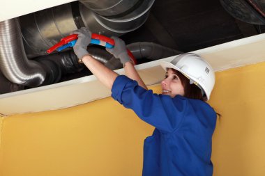 Female plumber at work. clipart