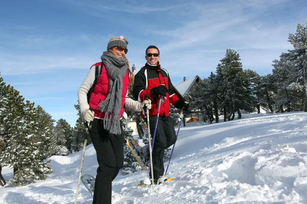 Пара, що ходить у снігоступах — стокове фото