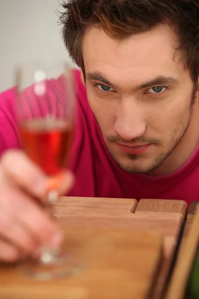 Homem determinado olhando para um copo de vinho — Fotografia de Stock