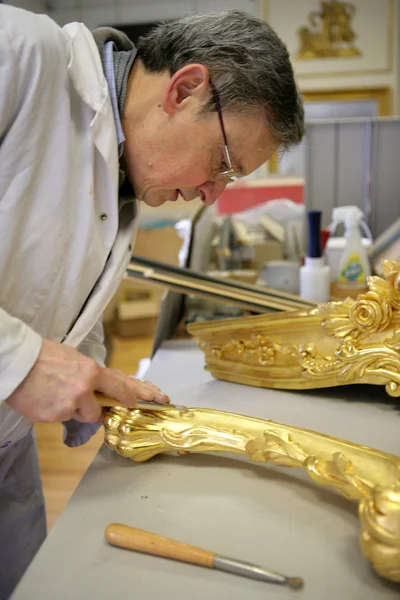 Man restoring golden picture frame — Stock Photo, Image