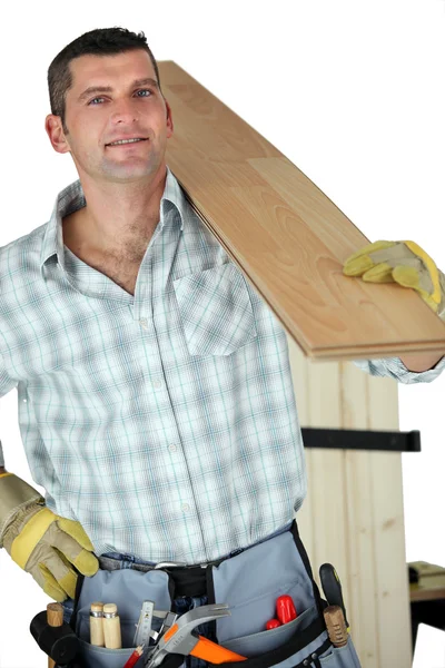 Handyman holding plank — Stock Photo, Image