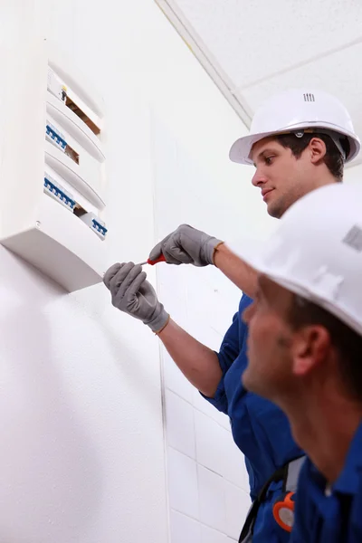 stock image Two electrical workers installing fuse box