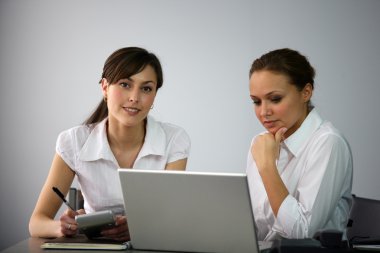 Clerical workers in front of a laptop clipart