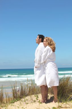 Couple in robes on the beach clipart