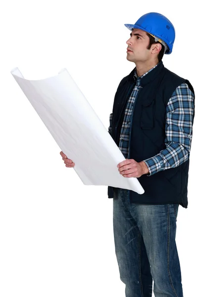 Byggnadsarbetare som verifierar en byggnad ritning — Stockfoto