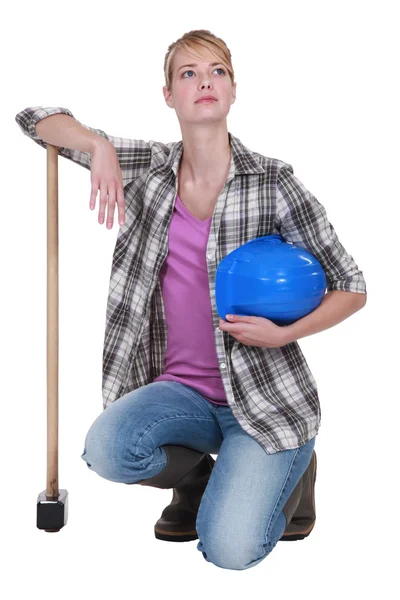 A kneeling tradeswoman holding her head up high — Stock Photo, Image