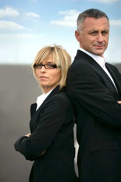 Homme d'affaires et femme d'affaires debout dos à dos — Photo