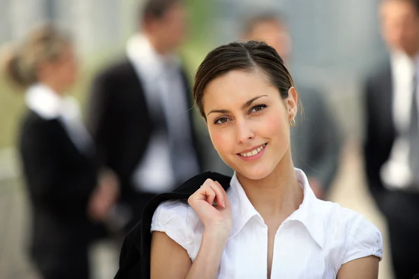 Businesswoman stood in front of colleagues outside — Stock Photo, Image