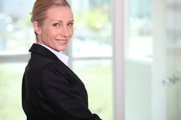 Porträt einer lächelnden Frau im schwarzen Anzug — Stockfoto