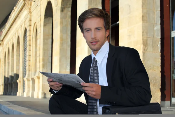 Joven hombre de negocios mirando un periódico —  Fotos de Stock