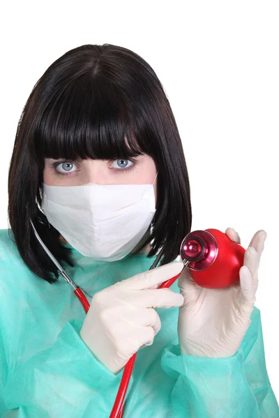 Doctor listening to a plastic heart with a stethoscope — Stock Photo, Image