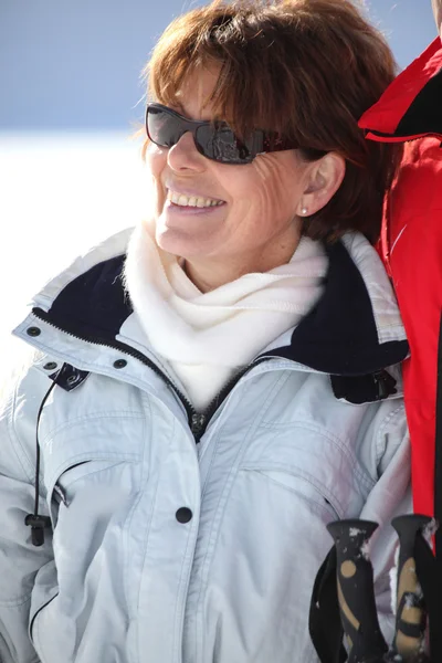 A smiling mature woman in a winter sports resort — Stock Photo, Image
