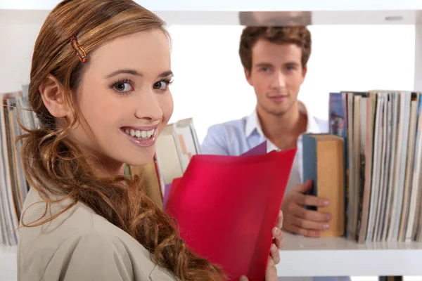 Paar flirten in een bibliotheek — Stockfoto