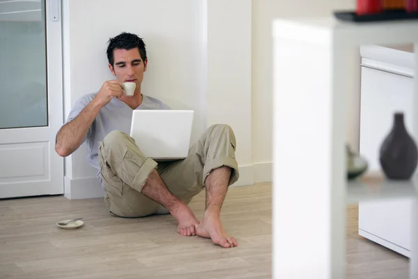 stock image Man sat on the floor at home drinking coffee