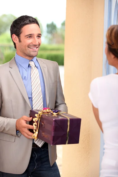 Мужчина доставляет подарок женщине — стоковое фото