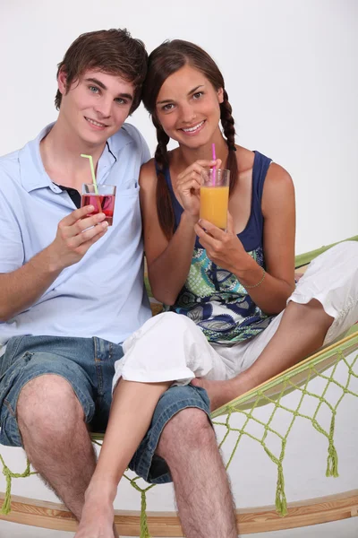 Casal tomando uma bebida em um hamac . — Fotografia de Stock