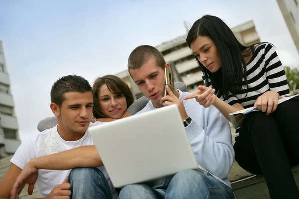Cuatro adolescentes usando computadora portátil — Foto de Stock