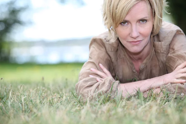 Kvinna som ligger på gräset — Stockfoto