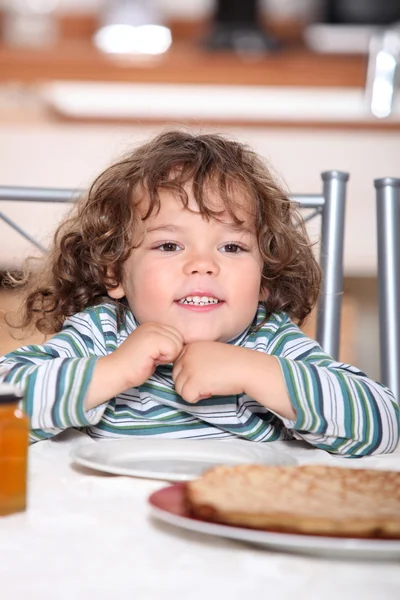 Маленькая девочка ест блинчики на ужин — стоковое фото