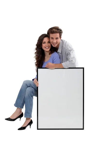 Couple with blank picture frame — Stock Photo, Image