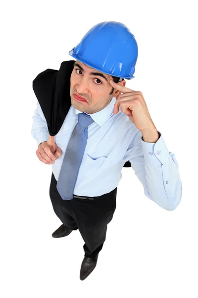 Engineer putting his finger to his head — Stock Photo, Image