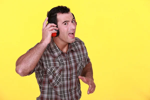 Homem usando defensores de orelha — Fotografia de Stock