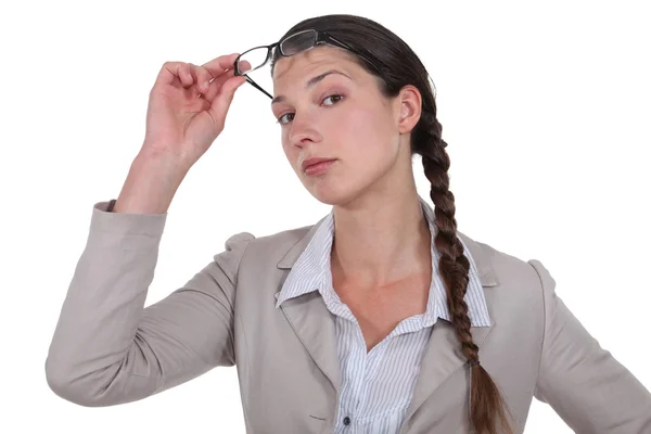 Curious businesswoman lifting glasses — Stock Photo, Image