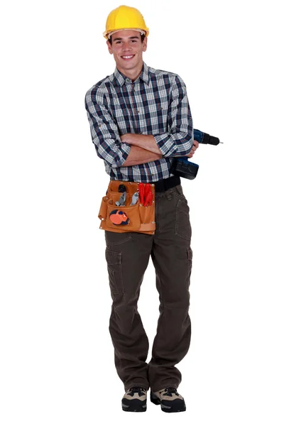 Mladý pracovník drží akumulátorový vrtací šroubovák — Stock fotografie