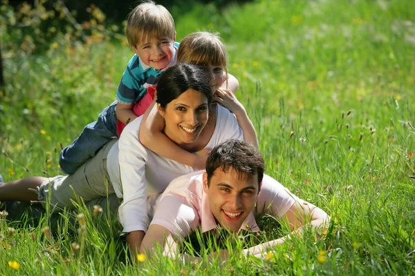Family laying together in the park — Stock Photo, Image