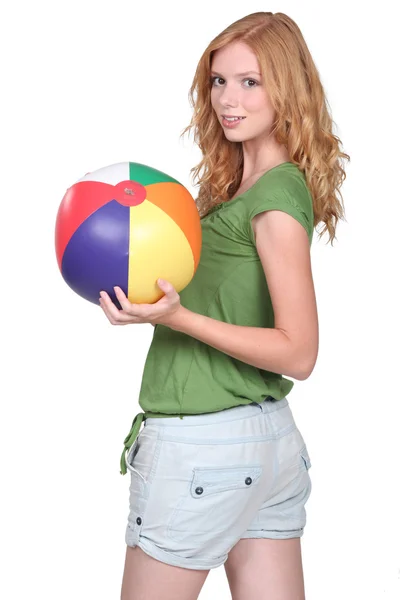 Chica sosteniendo pelota de playa Fotos De Stock