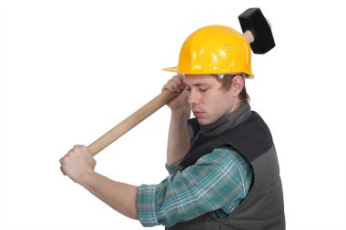 Young craftsman working with a huge hammer clipart